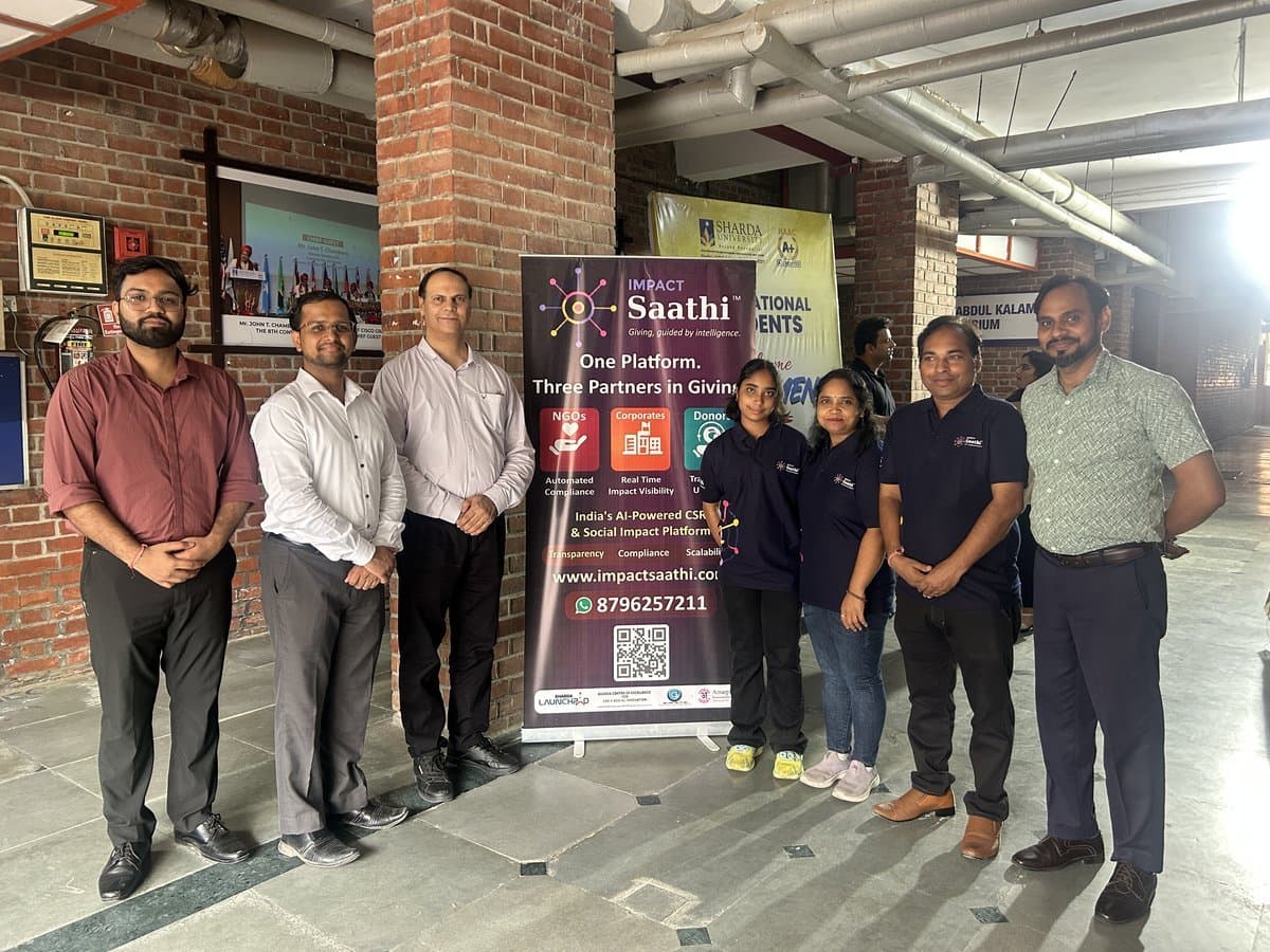 Impact Saathi team with rollup banner at Sharda University