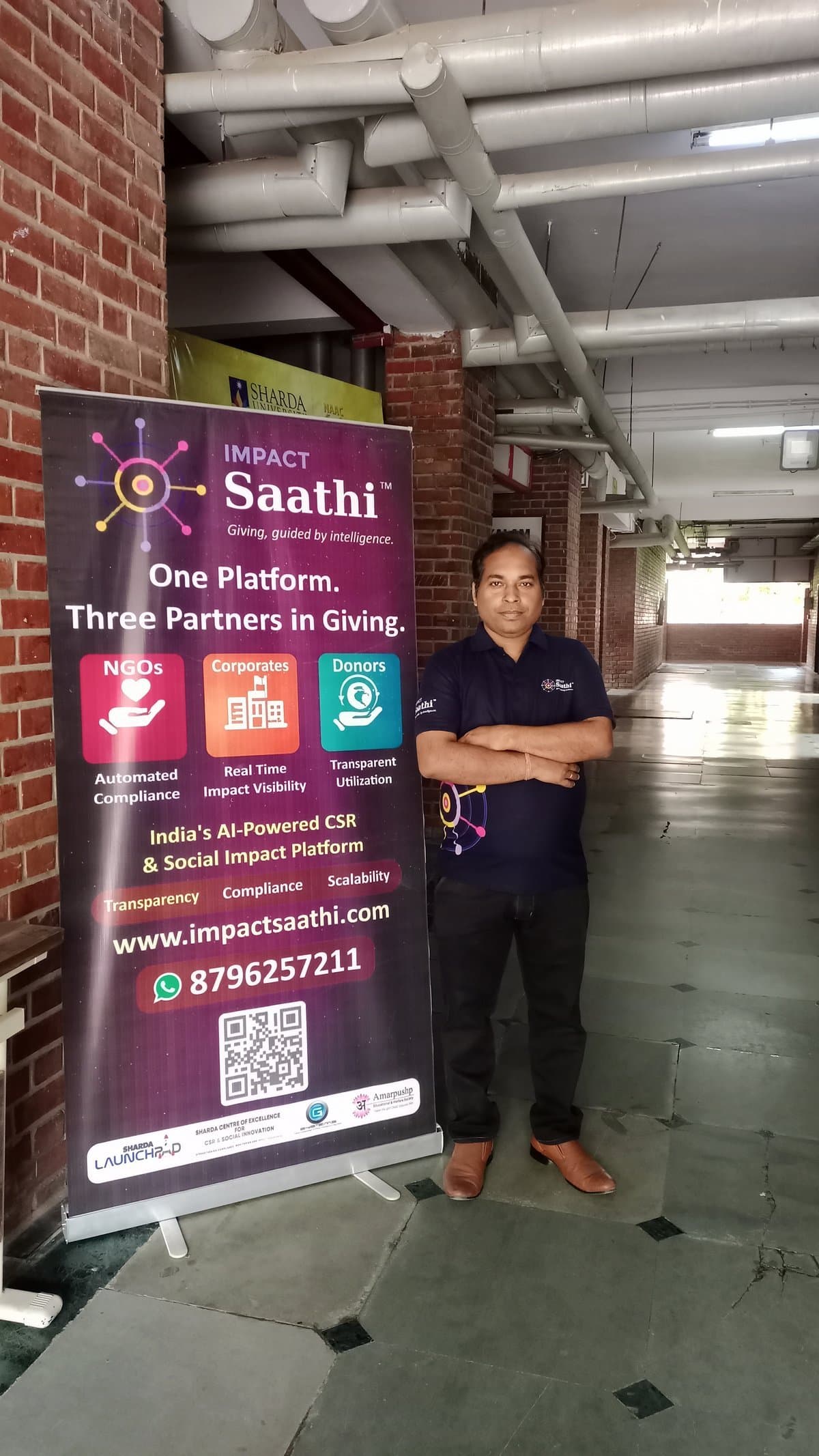 Ashish Kushwaha with Impact Saathi rollup banner at Sharda University